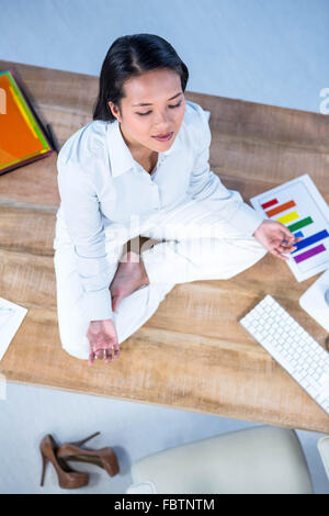 Friedliche Geschäftsfrau beim Yoga am Boden Stockfoto