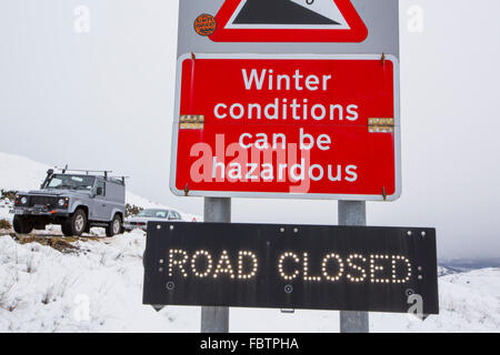 Ein Schild zeigt den Kampf bis zum Gipfel des Kirkstone Pass von Ambleside, durch Schnee, Lake District, Großbritannien geschlossen. Stockfoto