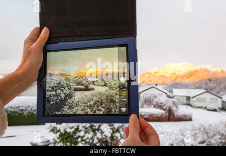 Sonnenaufgang über dem Loughrigg aus der Umgebung von Ambleside im Lake District nach ein schwere Nacht fällt Schnee, gefangen auf einem Ipad. Stockfoto