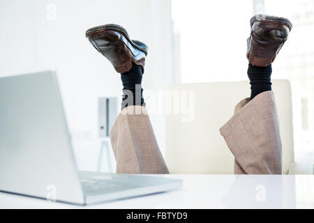 Unternehmer, die auf dem Boden liegend mit Füßen Stockfoto