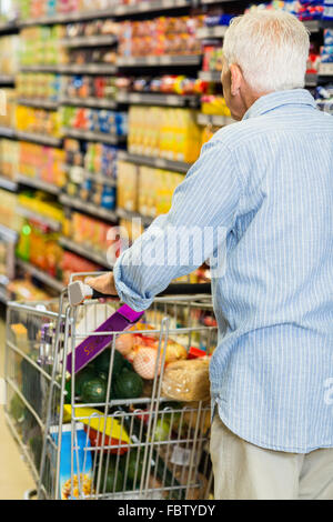 Ansicht der Rückseite des älteren Mann drücken Trolley Stockfoto