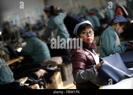 Frau leidet arbeitet bei einer Tuchfabrik in Stadt Huaibei, Provinz Anhui, Ost-China am 19. Januar 2016. Chinas Wirtschaft wuchs mit der langsamsten Geschwindigkeit in einem Vierteljahrhundert im Jahr 2015 Daten veröffentlichte am Dienstag zeigte.  Ganzjahres Wachstum von 6,9 % wurde nur knapp hinter den Erwartungen der Regierung von 7 %, aber im Gegensatz dazu, im Jahr 2014 lag bei 7,3 %. Stockfoto