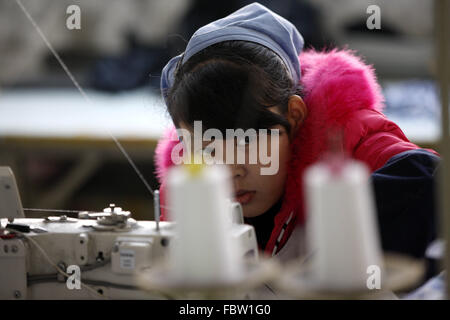 Frau leidet arbeitet bei einer Tuchfabrik in Stadt Huaibei, Provinz Anhui, Ost-China am 19. Januar 2016. Chinas Wirtschaft wuchs mit der langsamsten Geschwindigkeit in einem Vierteljahrhundert im Jahr 2015 Daten veröffentlichte am Dienstag zeigte.  Ganzjahres Wachstum von 6,9 % wurde nur knapp hinter den Erwartungen der Regierung von 7 %, aber im Gegensatz dazu, im Jahr 2014 lag bei 7,3 %. Stockfoto