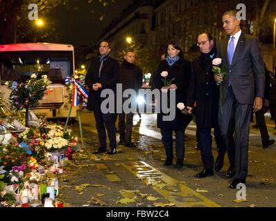 US-Präsident Barack Obama begleitet von Frankreichs Präsident François Hollande und Paris Bürgermeister Anne Hidalgo, machen eine unangekündigte Halt kurz nach Mitternacht am Denkmal außerhalb der Bataclan, die Website eines Terroranschlags Paris 30. November 2015 in Paris, Frankreich. Obama ist in Frankreich an den Klimagipfel teilzunehmen. Stockfoto