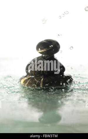 isolierte nass Zen Steinen mit Spritzwasser Tropfen Stockfoto