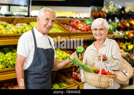 Ältere Kunden und Arbeitnehmer diskutieren Gemüse Stockfoto