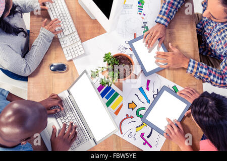Geschäftsleute, die mit Technologien am Schreibtisch im Büro Stockfoto