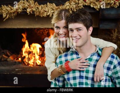 Junge romantisch zu zweit sitzen auf dem Sofa vor dem Kamin zu Hause Stockfoto