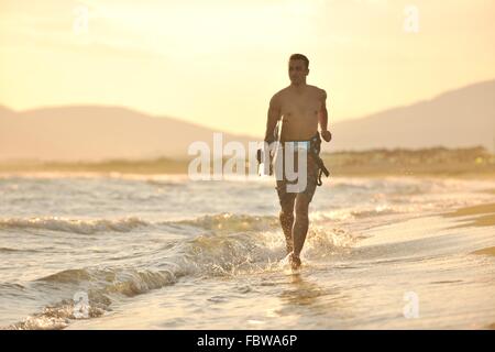 Porträt eines jungen Kitsurf am Strand bei Sonnenuntergang Stockfoto