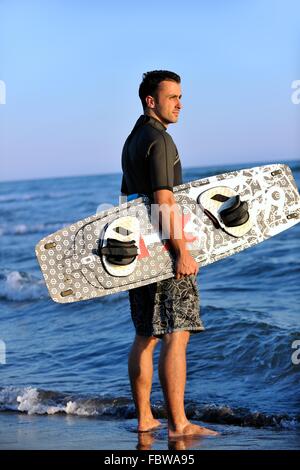 Porträt eines jungen Kitsurf am Strand bei Sonnenuntergang Stockfoto