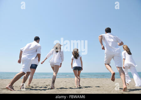 glückliche Menschengruppe haben Spaß und läuft auf Strand Stockfoto