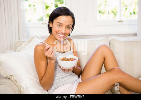 Lächelnde Brünette Essen Getreide Stockfoto