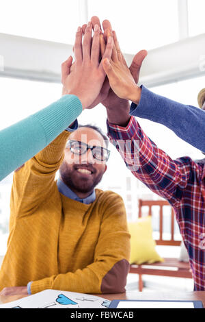 Business-Mann tun hohe fünf mit Team in Kreativbüro Stockfoto