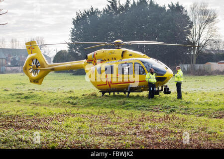 Prinz William, (stehend rechts) Piloten East Anglian Air Ambulance auf ein Feld in Newmarket ermächtigt einen Unfall, Suffolk UK Stockfoto