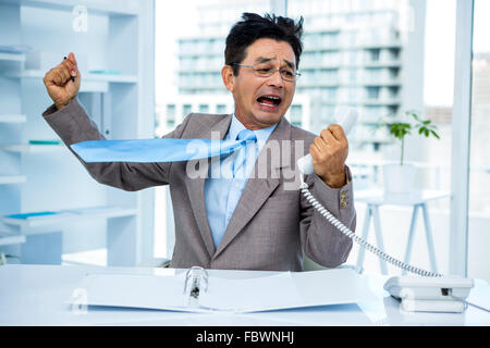 Geschäftsmann, schreien, als er hält, Telefon Stockfoto