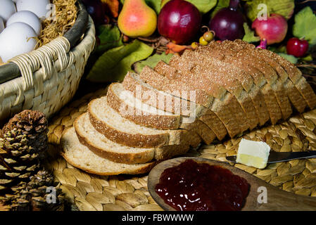 braune Vollkorn Schnittbrot mit Butter und Marmelade, Stillleben, in der Nähe auf und dunklen Ton Stockfoto