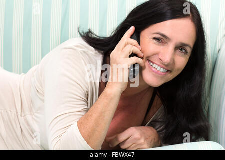 Schwarze behaarte Frau am Telefon Stockfoto