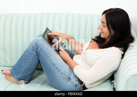 Schwarze behaarte Frau mit einem Tablet-PC