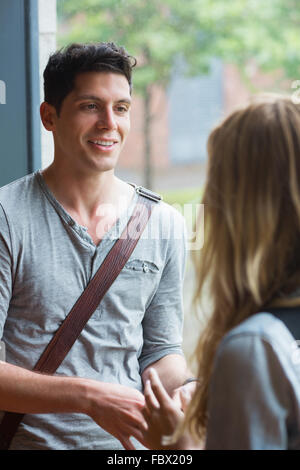 Lächelnde männlichen Studenten im Gespräch mit einem Freund Stockfoto