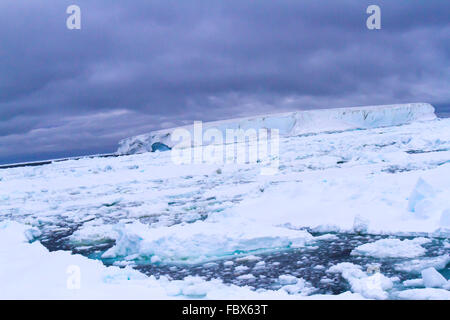 Tabellarischen Eisbergs in schwimmenden Eisfeld in der Antarktis Sonnenuntergang Landschaft. Stockfoto