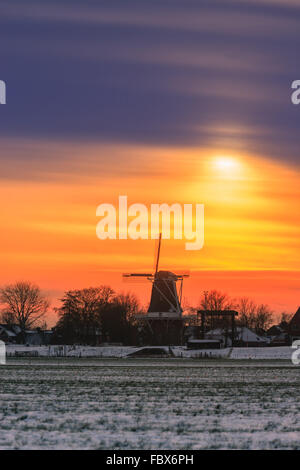 Windmühle de Meeuw in Garnwerd im Winter bei Sonnenuntergang, Groningen, Niederlande Stockfoto