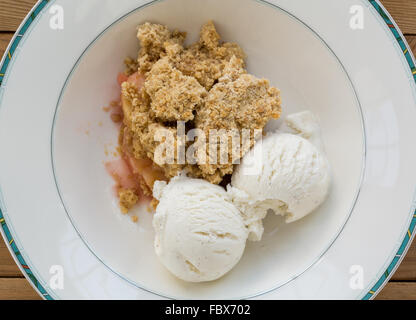 Traditionelle britische Apple crumble Pie in Schüssel mit Eis Stockfoto