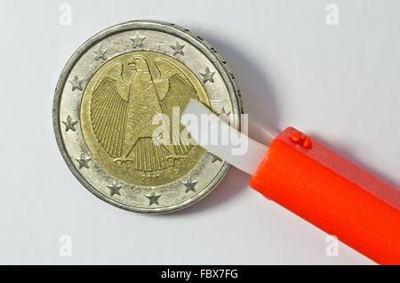 Zecken Zange halten deutsche 1 Euro Münze Stockfoto