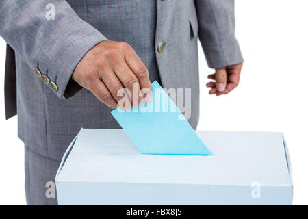 Geschäftsmann, die Stimmzettel in Abstimmung Feld setzen Stockfoto