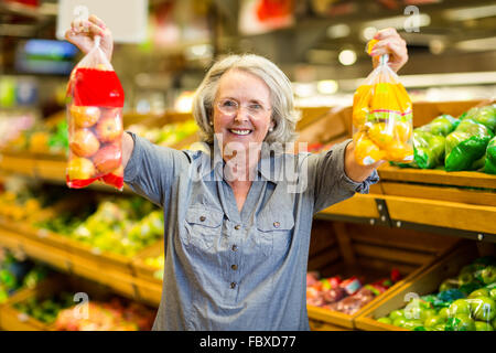 Senior glücklich Frau mit Tasche von Früchten Stockfoto