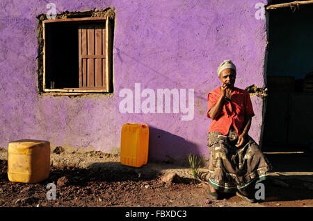 Afrikanische Reife Frau sitzt vor ihrem Haus in Logia (Logiya), Afar-Region, Äthiopien Stockfoto