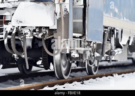 Detail mit gefrorenen Zug Wagen Puffer, Anschluss Links und Räder im Winter gedreht Stockfoto