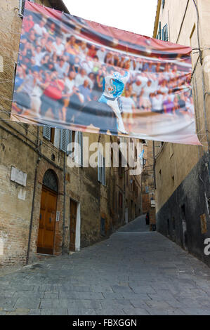 Ein Banner über eine Straße, die die Contrada Onda im Palio hängen. Via di San Salvadore, Siena, Toskana, Italien Stockfoto