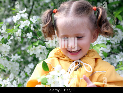 kleines Mädchen in der Nähe von blühenden Apfelbaum Stockfoto