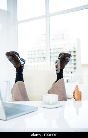 Unternehmer, die auf dem Boden liegend mit Füßen Stockfoto