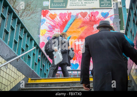 Ein paar umarmt vor ein Wandbild des Künstlers Hektad in East Village in New York als Hommage an den verstorbenen Musiker David Bowie auf Freitag, 15. Januar 2016. Bowie starb an Krebs im Alter von 69 Jahren am 10. Januar 2016 und nach seinen Wünschen wurde eingeäschert, mit seiner Familienplanung, ihn in einer privaten Zeremonie zu Ehren. (© Richard B. Levine) Stockfoto