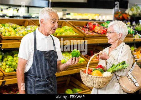 Ältere Kunden und Arbeitnehmer diskutieren Gemüse Stockfoto