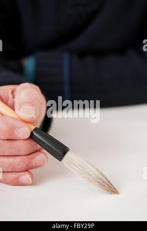 Mann, hält einen Kalligraphie-Pinsel mit Raum zum Hinzufügen von text Stockfoto