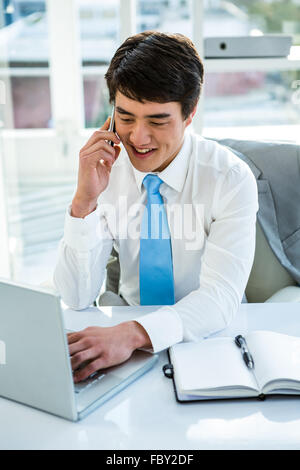 Beschäftigt asiatischen Geschäftsmann am Laptop arbeiten und mit der Aufforderung Stockfoto