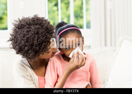 Mutter hilft Tochter ihre Nase weht Stockfoto
