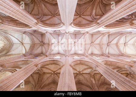 Aufblick auf sich kreuzende Rippen-Gotische Gewölbe und Steinsäulen im Batalha-Kloster, Portugal. Stockfoto