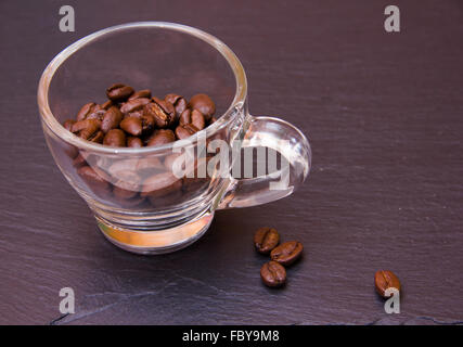 Kaffeebohnen in der Tasse auf Schiefer Stockfoto