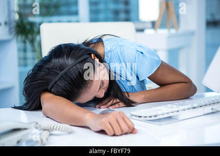 Müde an ihrem Schreibtisch schlafen Geschäftsfrau Stockfoto