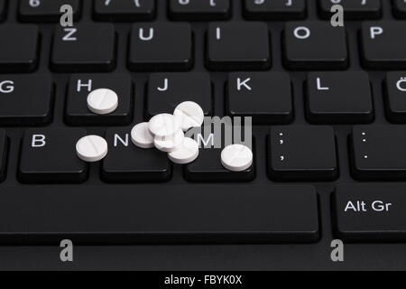 Pillen auf Tastatur Stockfoto