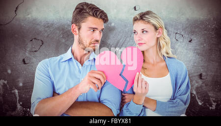 Zusammengesetztes Bild des Paares hält zwei Hälften des gebrochenen Herzens Stockfoto