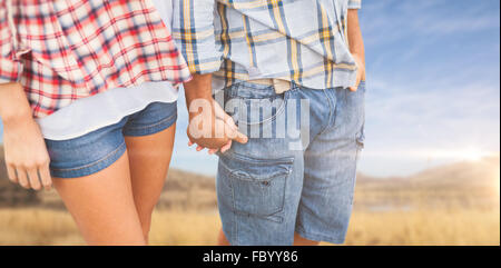 Zusammengesetztes Bild des Paares in Check-Hemden und Jeans, die Hand in Hand Stockfoto