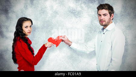 Zusammengesetztes Bild Porträt des Paares halten rote gebrochene Herzform Stockfoto