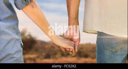 Zusammengesetztes Bild paar Holding Hände im park Stockfoto