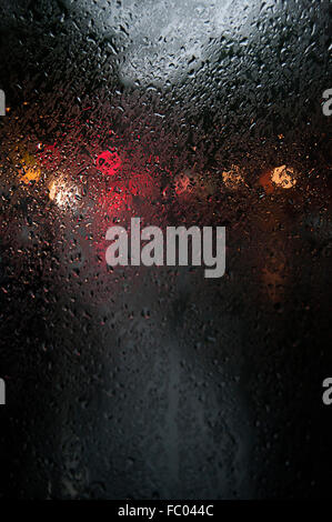Wassertropfen Sie auf einem Autofenster in der Nacht in New York City. Stockfoto