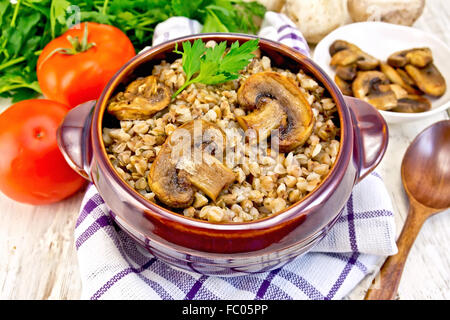 Buchweizen mit Champignons in Ton Schüssel auf Serviette Stockfoto