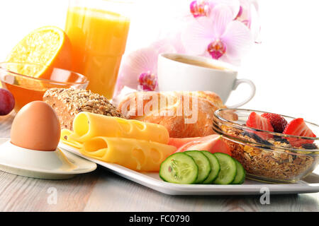 Frühstück mit Kaffee, Brötchen, Ei, Orangensaft, Müsli und chee Stockfoto